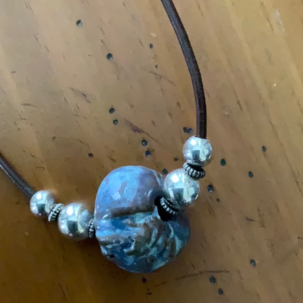 Brown chord with blue ceramic bead necklace.  Sterling silver clasp and accents